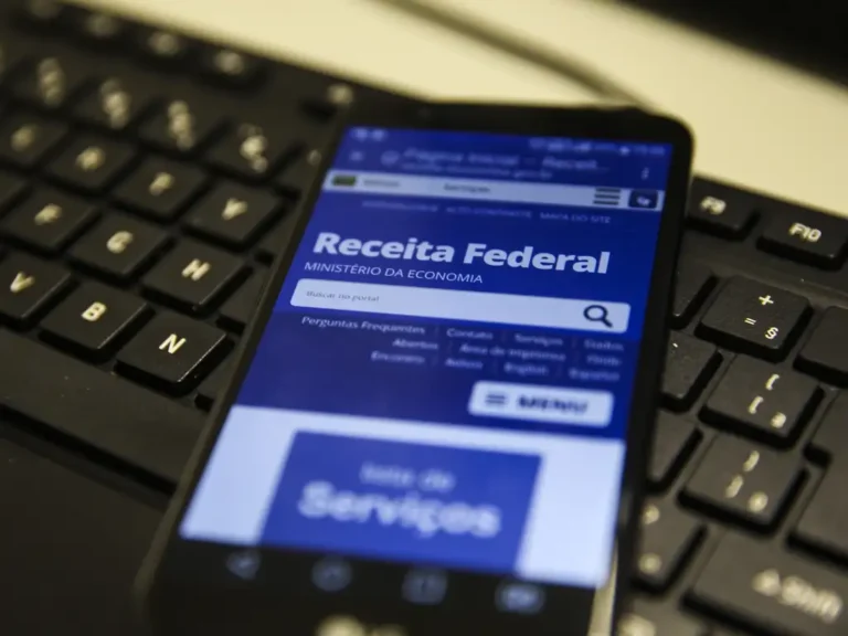 Pessoa segurando celular com tela da Receita Federal, referência a crédito presumido de ICMS
